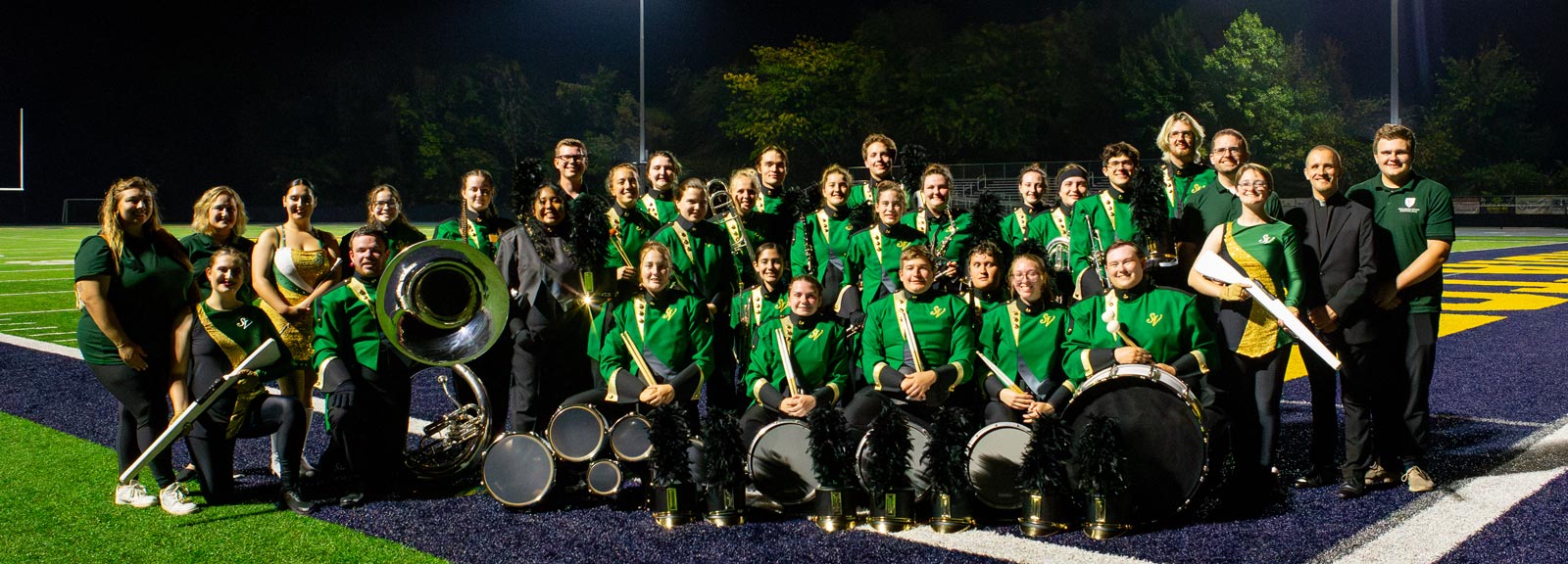 group photo of the marching band in uniform holding instruments