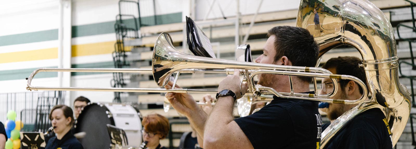 close up photo of tuba and trombone players during a performance