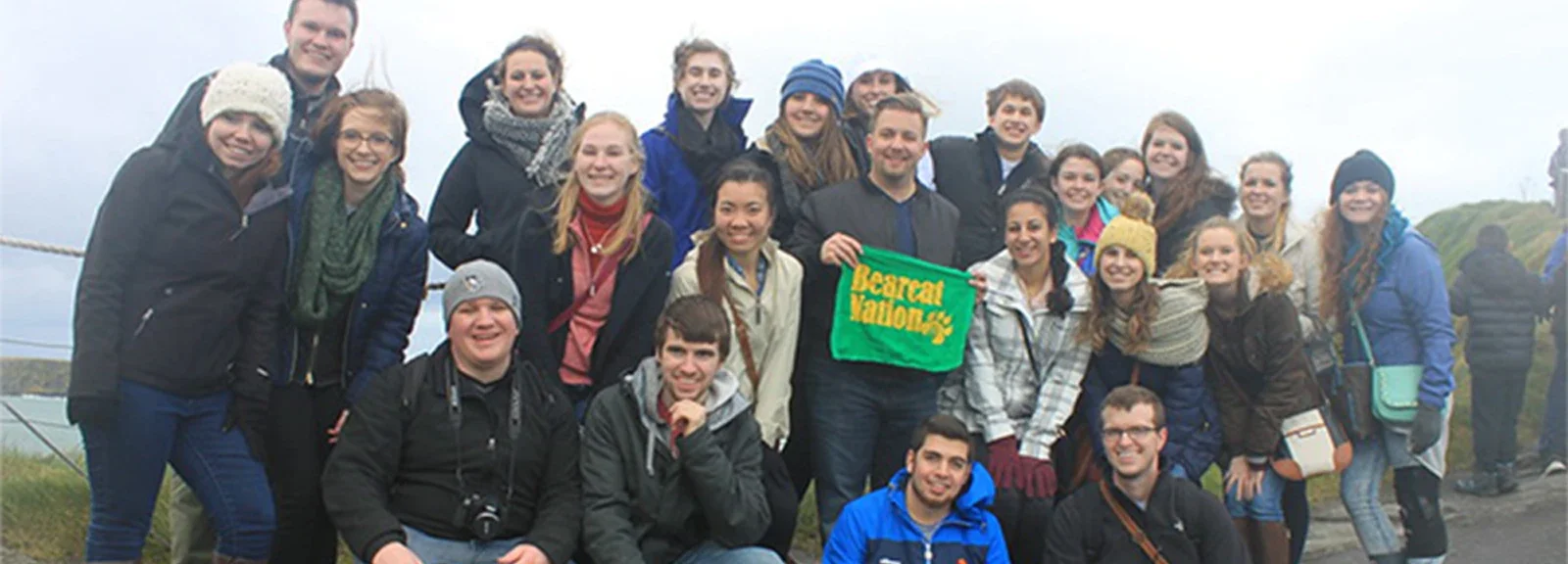 Group photo of students and staff posing together outdoors, holding a banner that reads "Recreation Management."