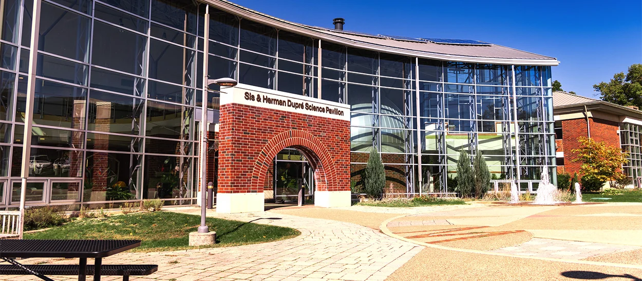 Exterior view of the Science Pavilion showcasing its modern architecture and glass facade surrounded by landscaped grounds.