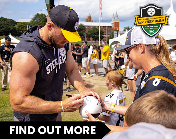 Photo of Pittsburgh Steeler Player autographing football for a fan at training camp.