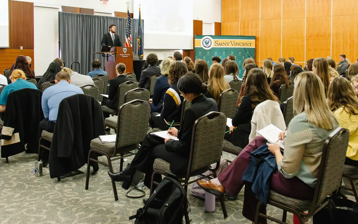 An audience composed of students listening attentively to a speaker at a Saint Vincent University event.