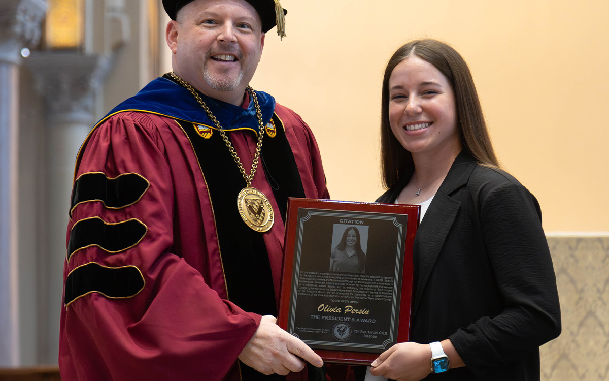 Father Paul posing for a photo with Olivia Persin and her award.