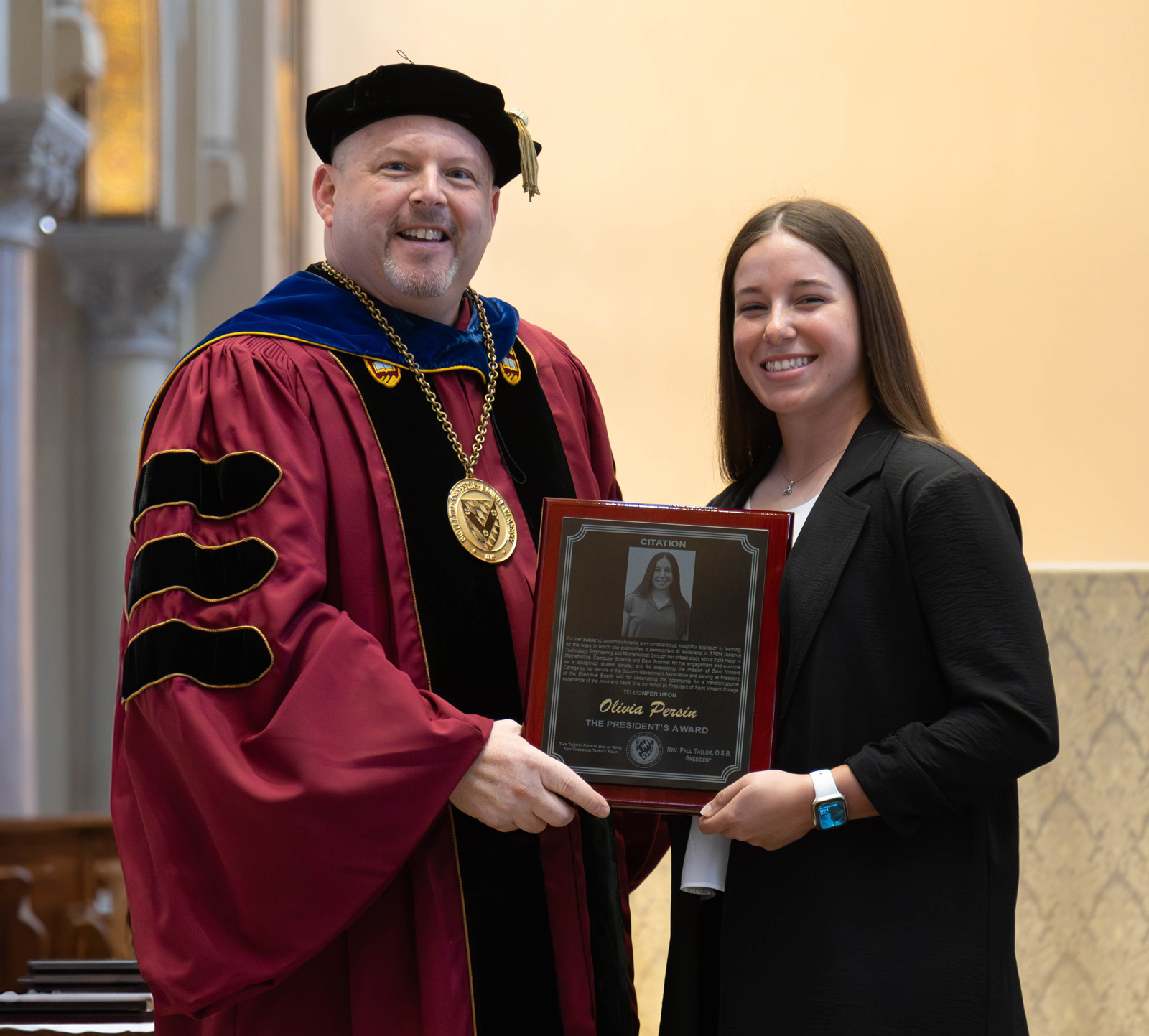 Father Paul posing for a photo with Olivia Persin and her award.