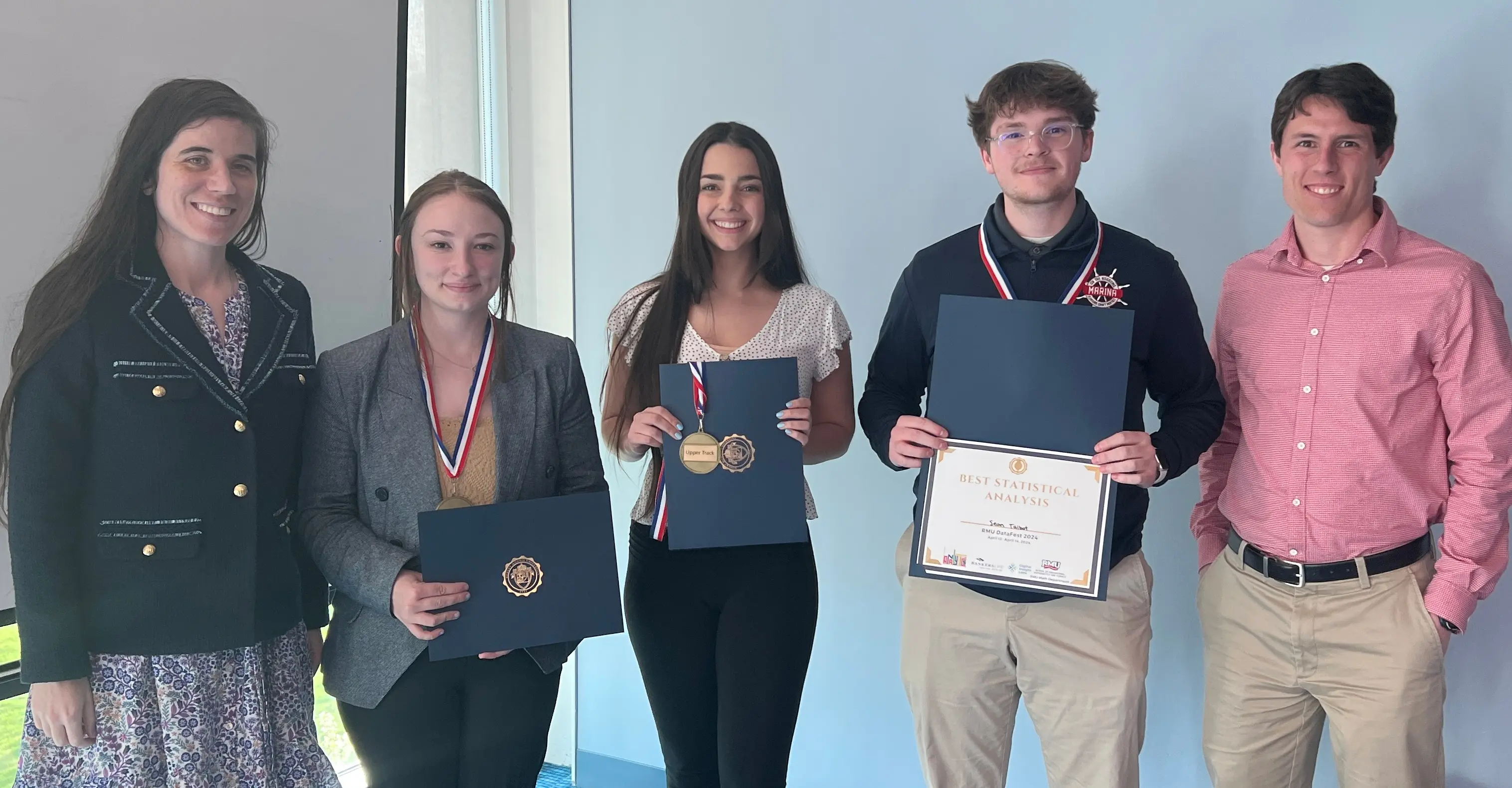 Students posing with awards and certificates, celebrating their achievements at a recognition event.