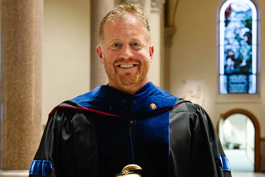 Dr. Eric J. Kocian holding the Thoburn Excellence in Teaching Award during the annual Founders’ Day Honors Convocation