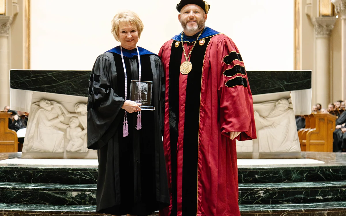 Dr. Helen Burns and Father Paul Taylor posing with the 2024 Projecktenmacher Award she received at the Saint Vincent Archabbey Basilica.