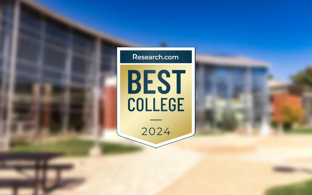 Best College 2024 logo from Research.com displayed in front of a modern campus building.